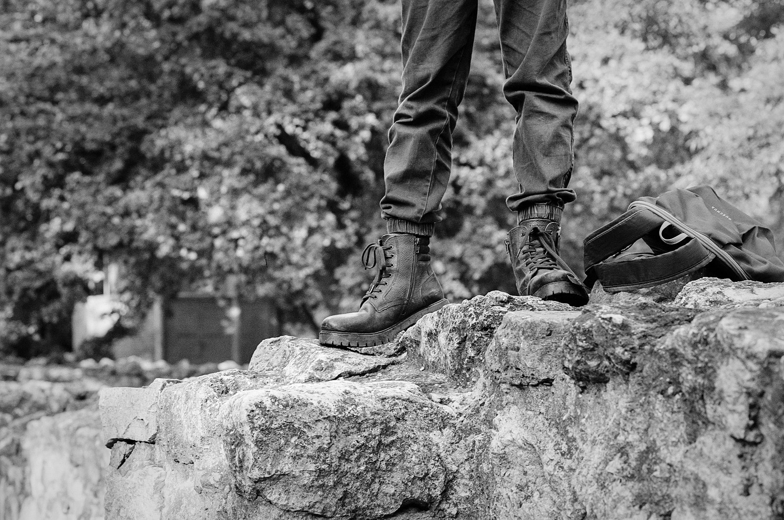 Close detail of weathered walking boots and a wooden staff resting on an old stone step